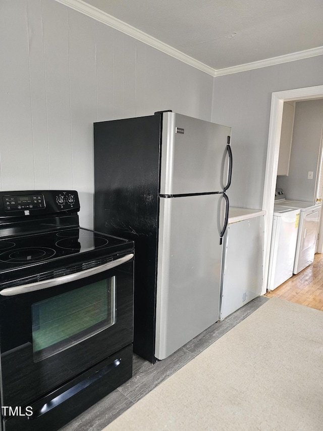 910 Marshall St, Roanoke Rapids, NC 27870 - kitchen with washing machine and dryer, light wood-type flooring, stainless steel refrigerator, black electric range oven, and crown molding