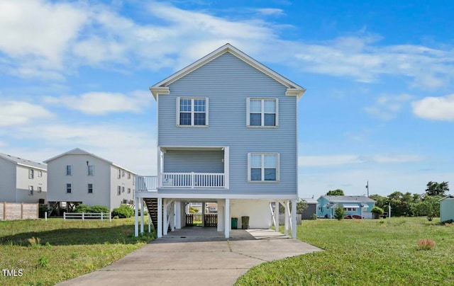 raised beach house featuring a carport and a front lawn