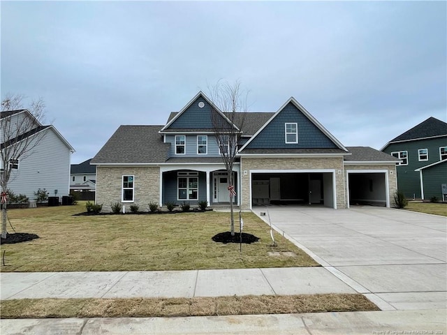 view of front facade featuring covered porch, a front yard, and a garage