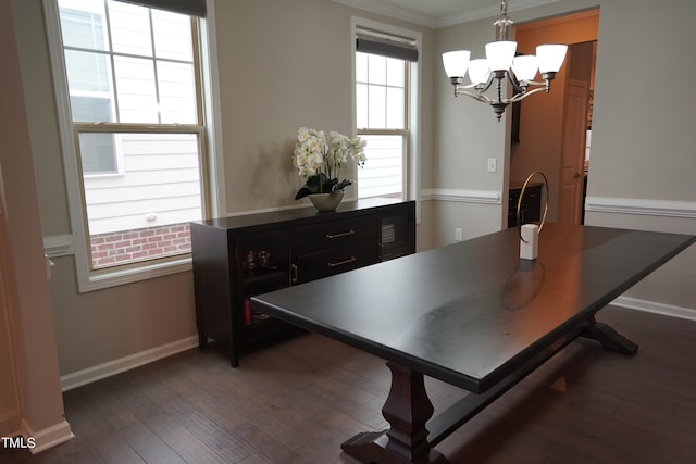 dining space with dark hardwood / wood-style floors, an inviting chandelier, and ornamental molding