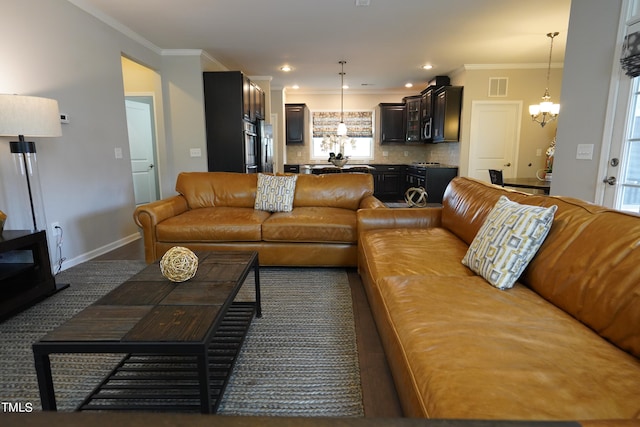 living room with an inviting chandelier and ornamental molding