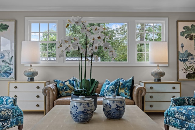 sitting room featuring a healthy amount of sunlight, crown molding, and light carpet