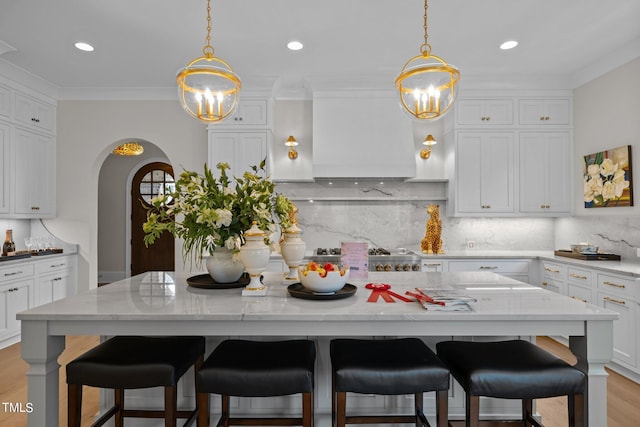 kitchen featuring pendant lighting, light wood-type flooring, a center island, and a breakfast bar area