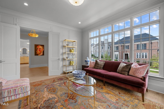 living room with ornamental molding and light hardwood / wood-style flooring