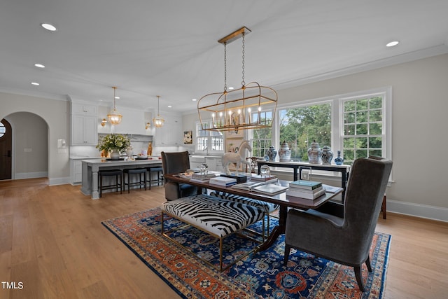 dining space with light wood-type flooring and crown molding