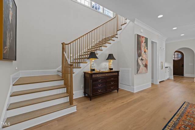 stairs with crown molding and hardwood / wood-style floors