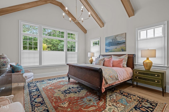 bedroom with multiple windows, high vaulted ceiling, beamed ceiling, and hardwood / wood-style flooring