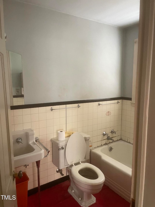 bathroom featuring tile walls, sink, toilet, and a bath