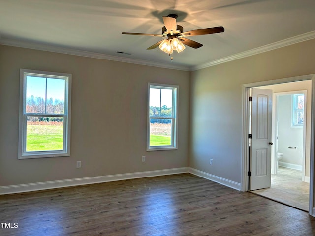 spare room featuring plenty of natural light, ceiling fan, crown molding, and dark wood-type flooring