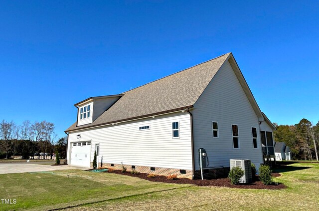 view of side of home with a yard, a garage, and central AC unit