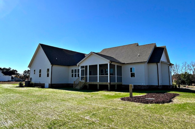 back of house featuring central air condition unit, a sunroom, and a yard