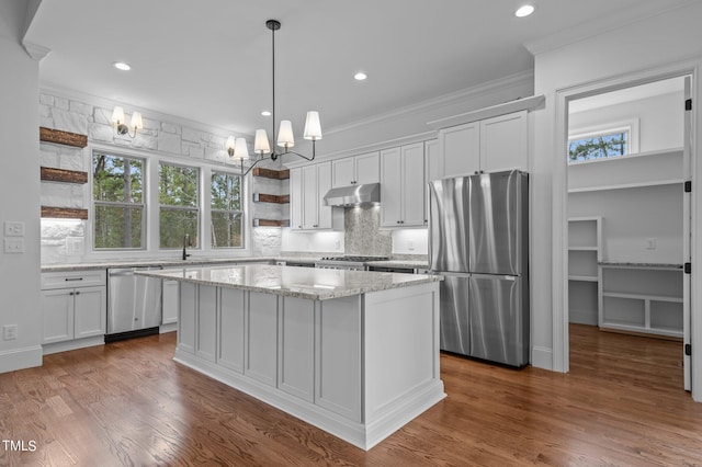 kitchen with appliances with stainless steel finishes, white cabinetry, a kitchen island, and dark hardwood / wood-style flooring