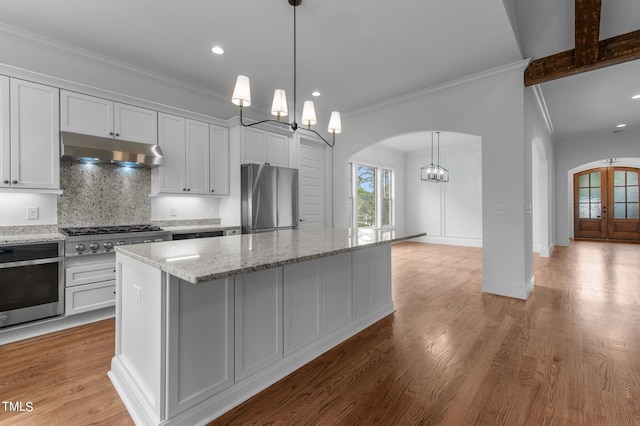 kitchen featuring stainless steel appliances, white cabinetry, light hardwood / wood-style floors, and a center island