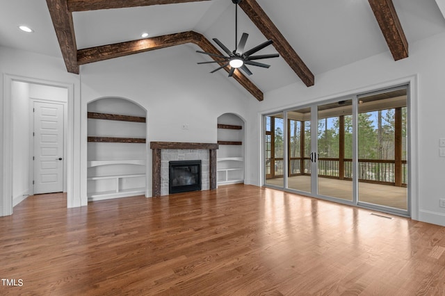 unfurnished living room featuring ceiling fan, light hardwood / wood-style floors, and built in shelves