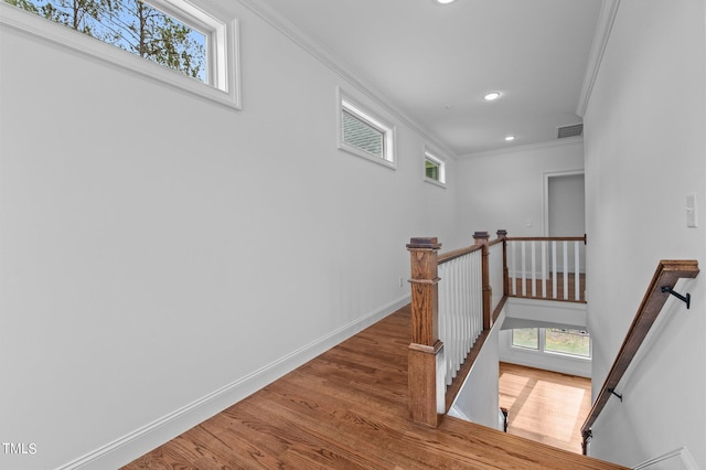 stairs with crown molding and hardwood / wood-style flooring