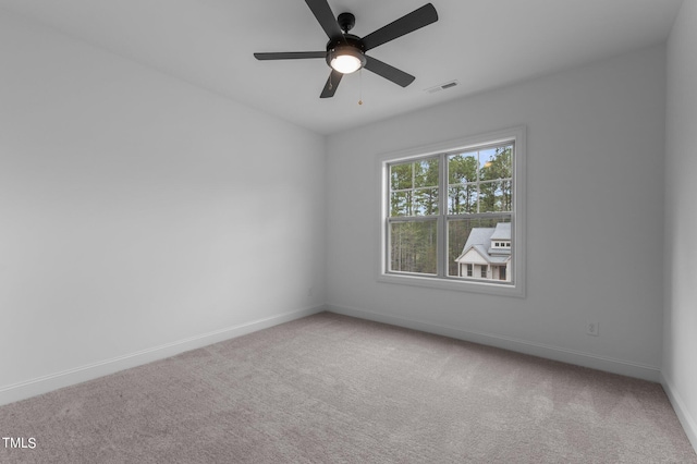 carpeted spare room featuring ceiling fan