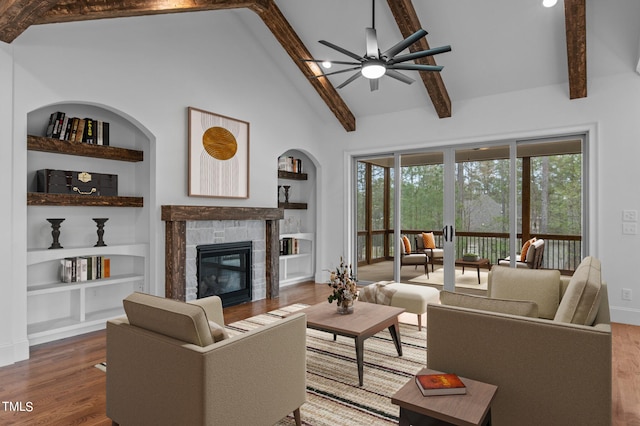 living room featuring a fireplace, hardwood / wood-style floors, ceiling fan, and built in features