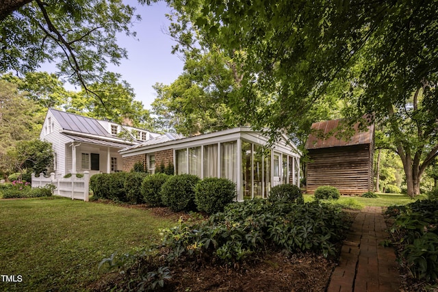 6720 Mebane Oaks Rd, Mebane, NC 27302 - rear view of house featuring a lawn, a standing seam roof, metal roof, and a sunroom