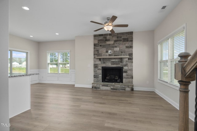 unfurnished living room with plenty of natural light, a fireplace, and hardwood / wood-style flooring