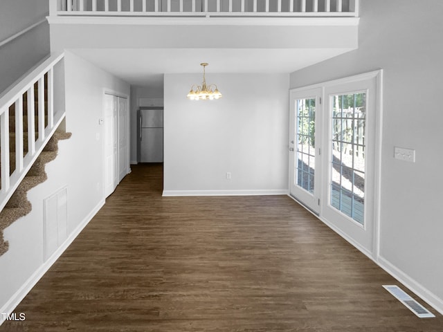 unfurnished room with dark hardwood / wood-style flooring and a notable chandelier