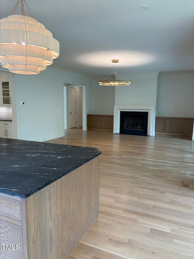 2227 Wheeler Rd, Raleigh, NC 27607 - kitchen with light wood-style flooring, dark stone counters, open floor plan, and pendant lighting