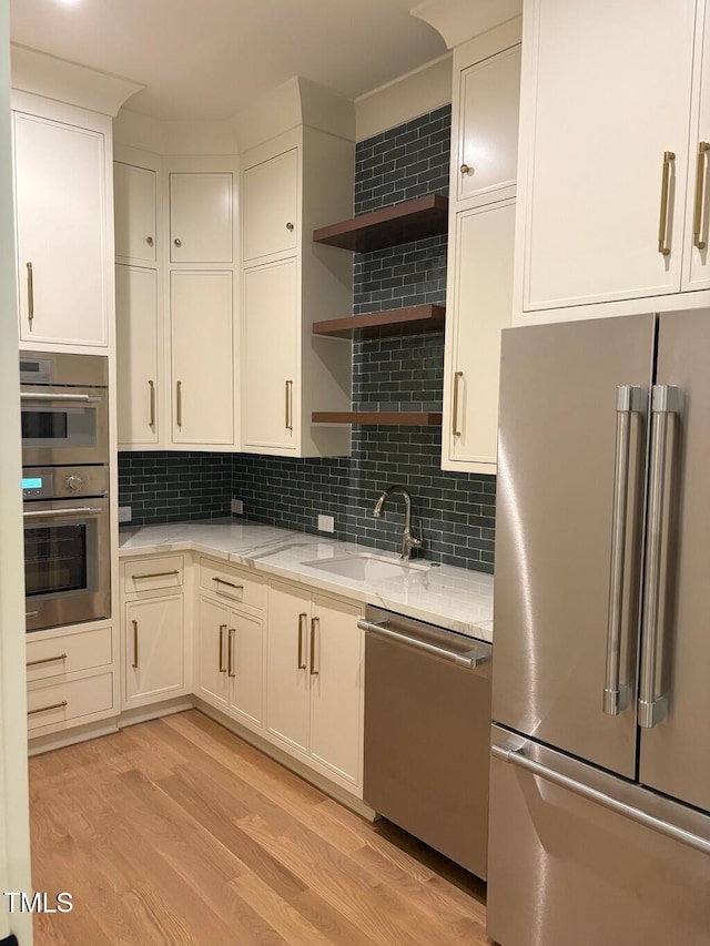 2227 Wheeler Rd, Raleigh, NC 27607 - kitchen with appliances with stainless steel finishes, a sink, light wood-style flooring, and tasteful backsplash