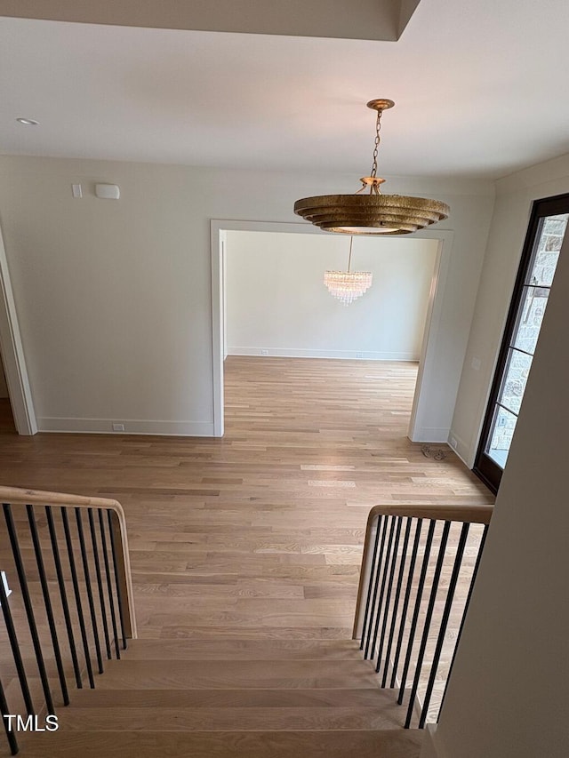 2227 Wheeler Rd, Raleigh, NC 27607 - hallway featuring light wood-type flooring, baseboards, and a chandelier
