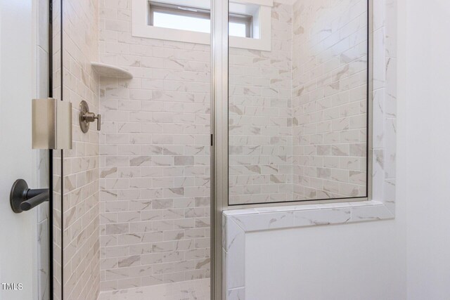 bathroom with a shower with door