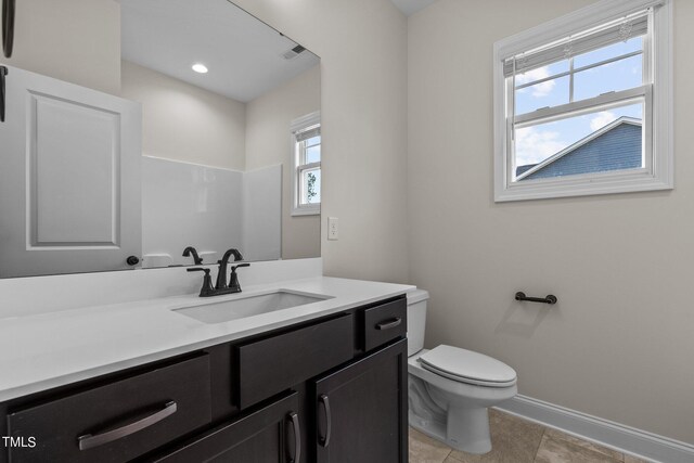 bathroom with vanity, toilet, tile patterned flooring, and plenty of natural light