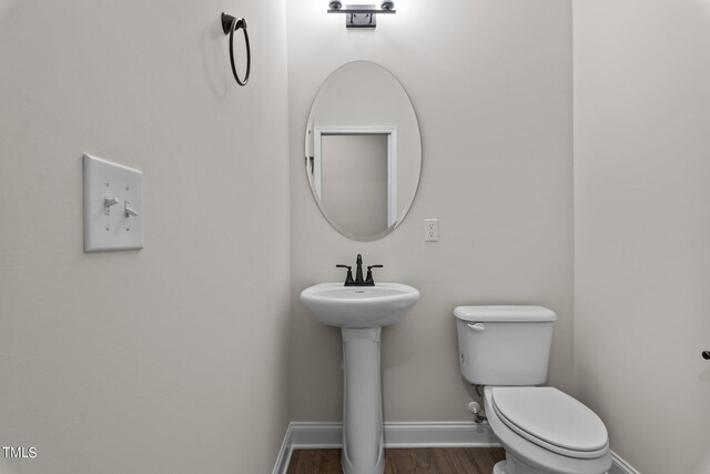 bathroom featuring hardwood / wood-style flooring and toilet