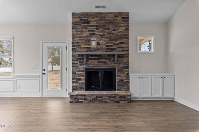 unfurnished living room with a brick fireplace and hardwood / wood-style flooring