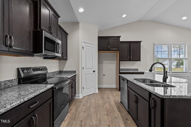 kitchen featuring appliances with stainless steel finishes, light hardwood / wood-style flooring, sink, light stone counters, and lofted ceiling