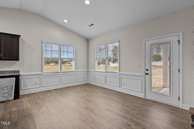 interior space featuring a wealth of natural light, lofted ceiling, and hardwood / wood-style flooring