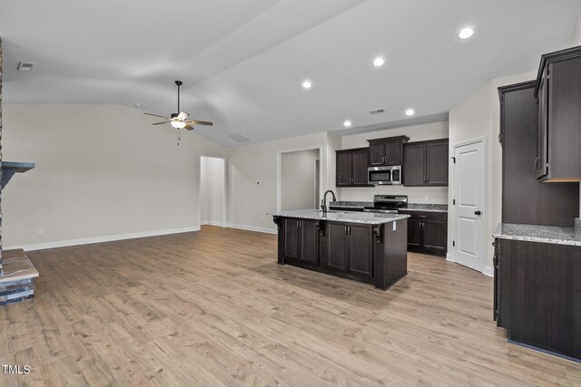 kitchen featuring stainless steel appliances, a center island with sink, light hardwood / wood-style floors, lofted ceiling, and ceiling fan