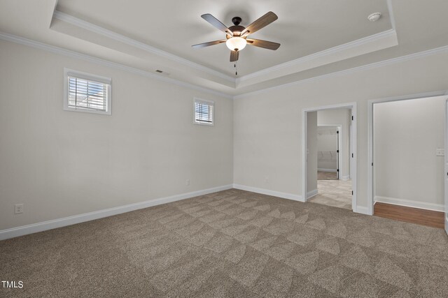 spare room featuring carpet, ceiling fan, a raised ceiling, and ornamental molding