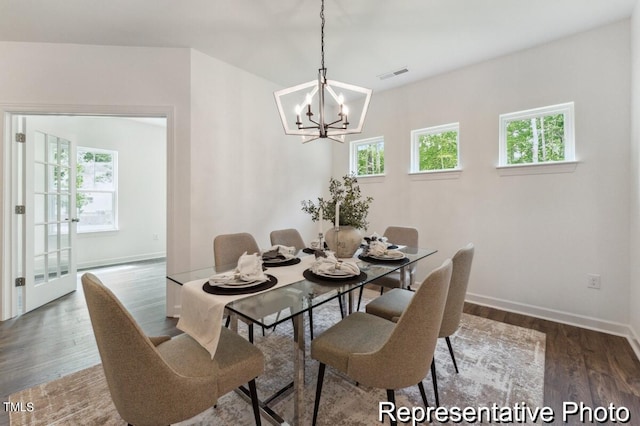 dining room with hardwood / wood-style flooring, a notable chandelier, and a healthy amount of sunlight