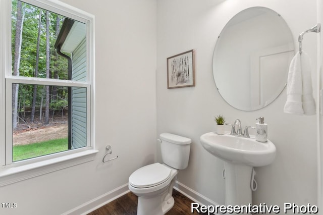 bathroom with hardwood / wood-style floors, toilet, and a wealth of natural light