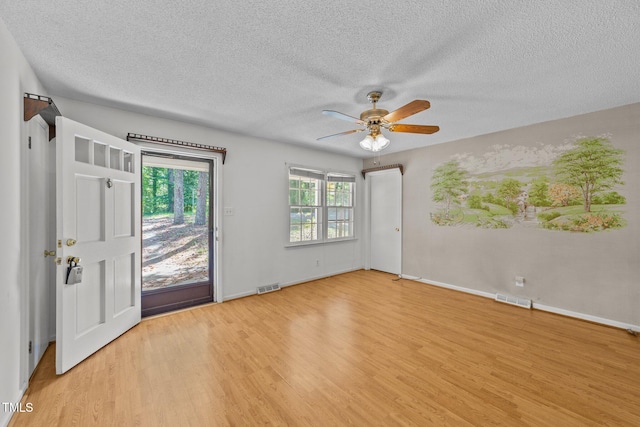 interior space with ceiling fan, light hardwood / wood-style floors, and a textured ceiling