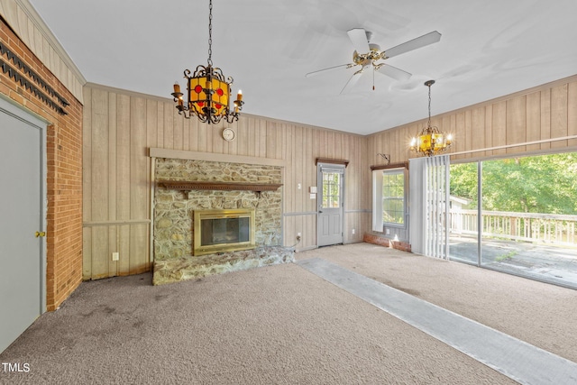 unfurnished living room featuring ceiling fan, wooden walls, a fireplace, and carpet