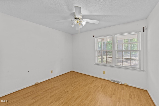 spare room with ceiling fan, light hardwood / wood-style floors, and a textured ceiling