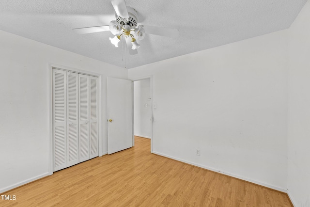 unfurnished bedroom featuring ceiling fan, a textured ceiling, light hardwood / wood-style flooring, and a closet