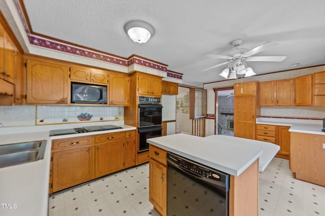 kitchen featuring black appliances, ceiling fan, a center island, sink, and a textured ceiling