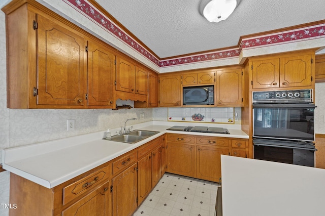 kitchen featuring black appliances, sink, and a textured ceiling