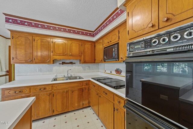 kitchen featuring black appliances, sink, and a textured ceiling