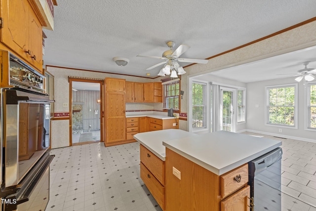 kitchen featuring ceiling fan, a center island, crown molding, and black appliances