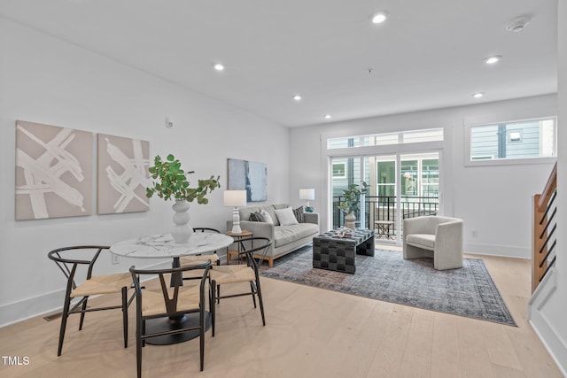 living room with a wealth of natural light, light wood-type flooring, baseboards, and recessed lighting