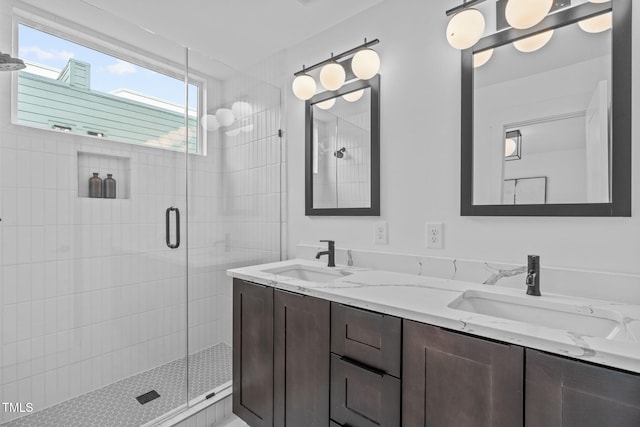 bathroom featuring a sink, a shower stall, and double vanity