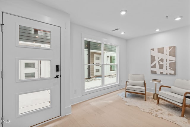 foyer with baseboards, wood finished floors, visible vents, and recessed lighting