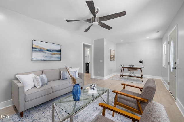 living room featuring light hardwood / wood-style flooring and ceiling fan