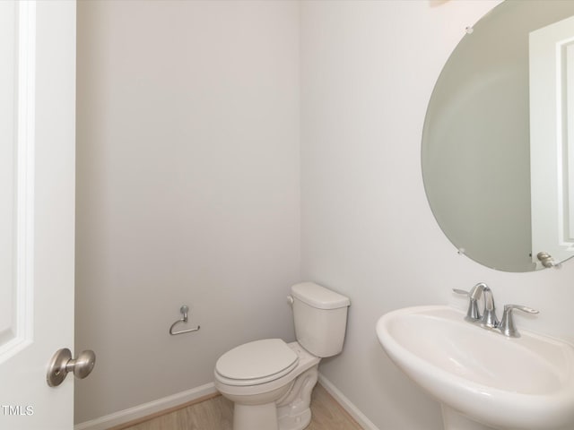 bathroom with sink, hardwood / wood-style flooring, and toilet